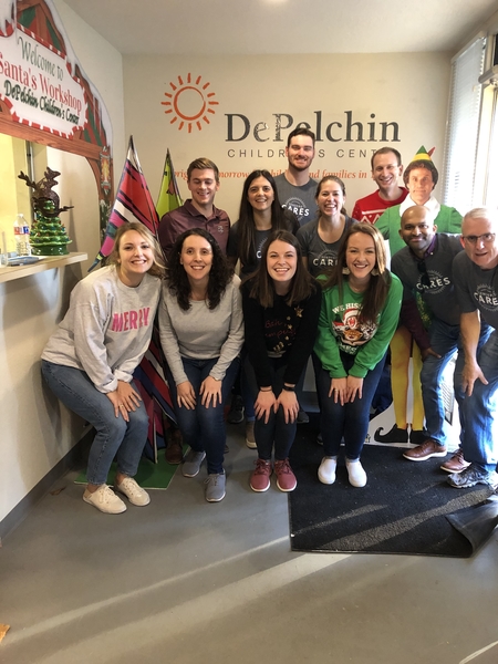 A group of males and females posing for a group photo in the DePelchin Children's Center lobby