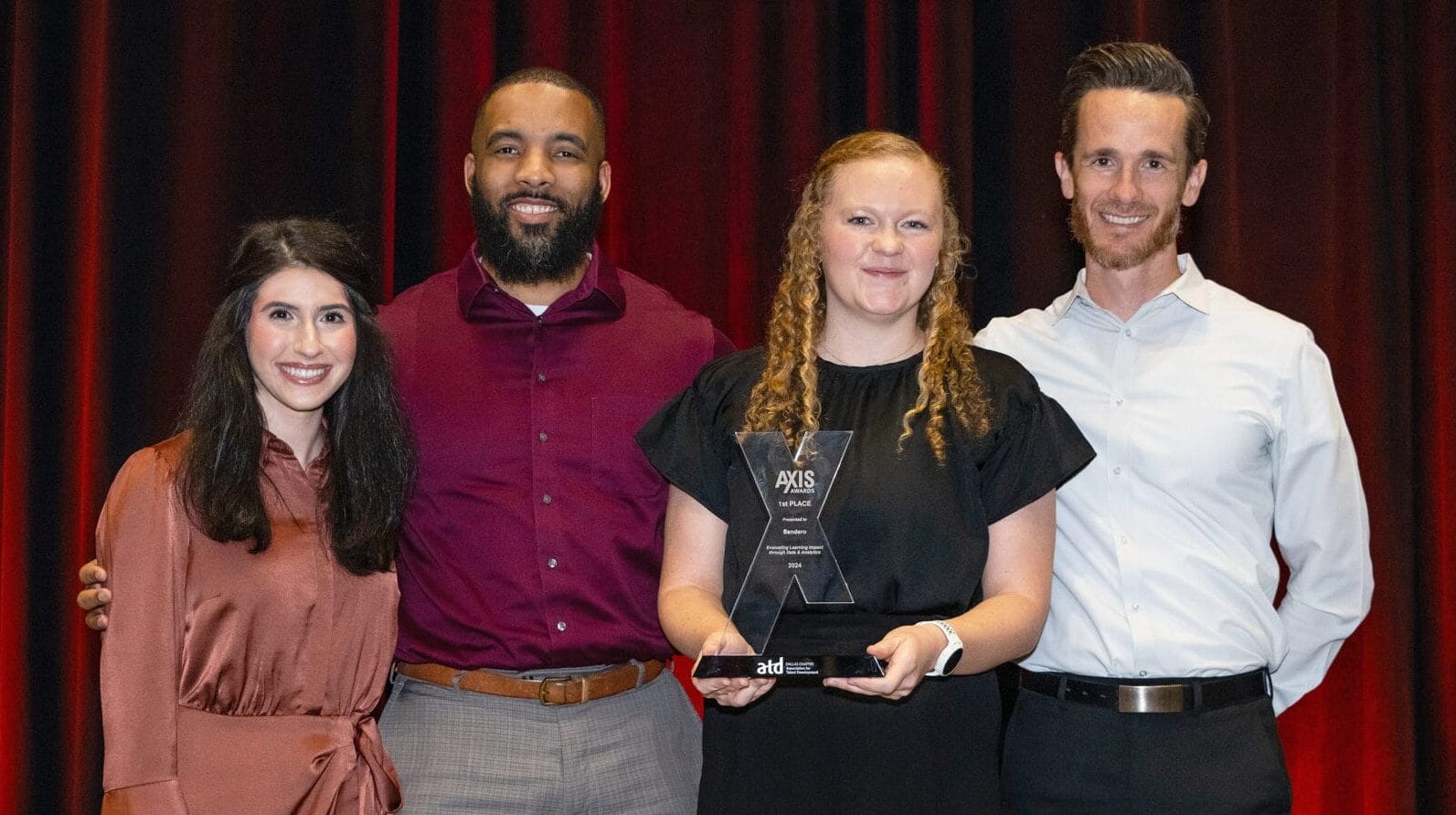 Four members of Sendero's learning & development team holding their AXIs Award.