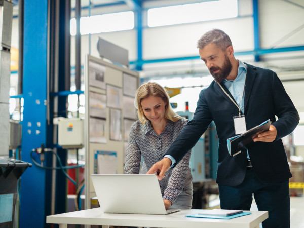 Industrial team analyzing data or managing operations in high tech manufacturing plant.