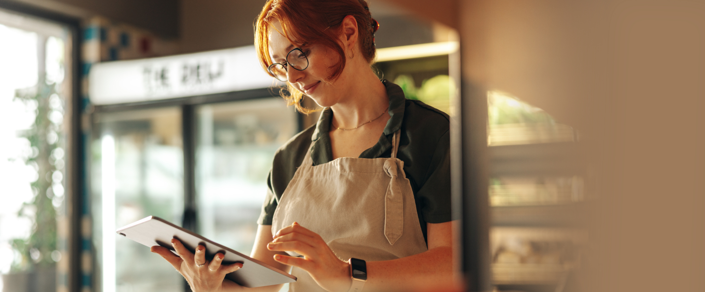 Grocery store employee standing with a tablet