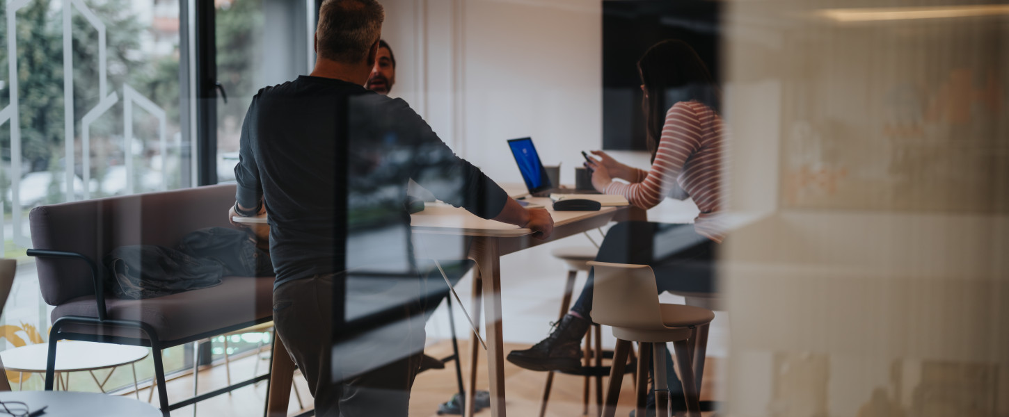 Blurred image showing people meeting in an office