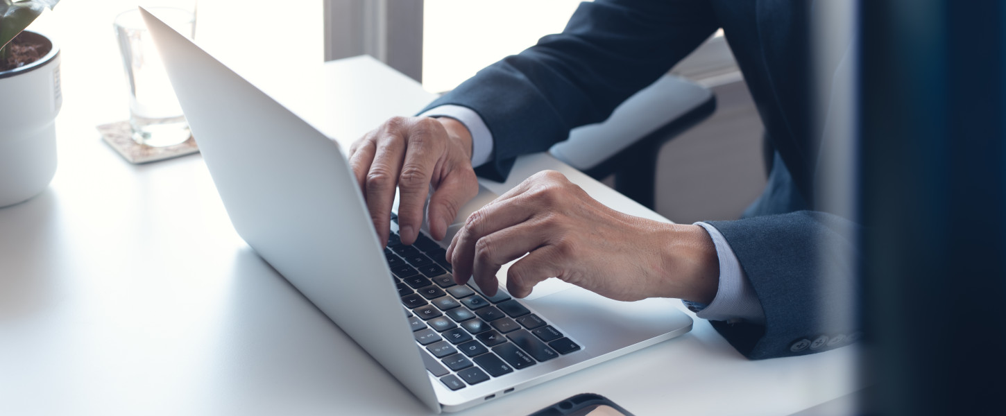 Image of a man working on a laptop