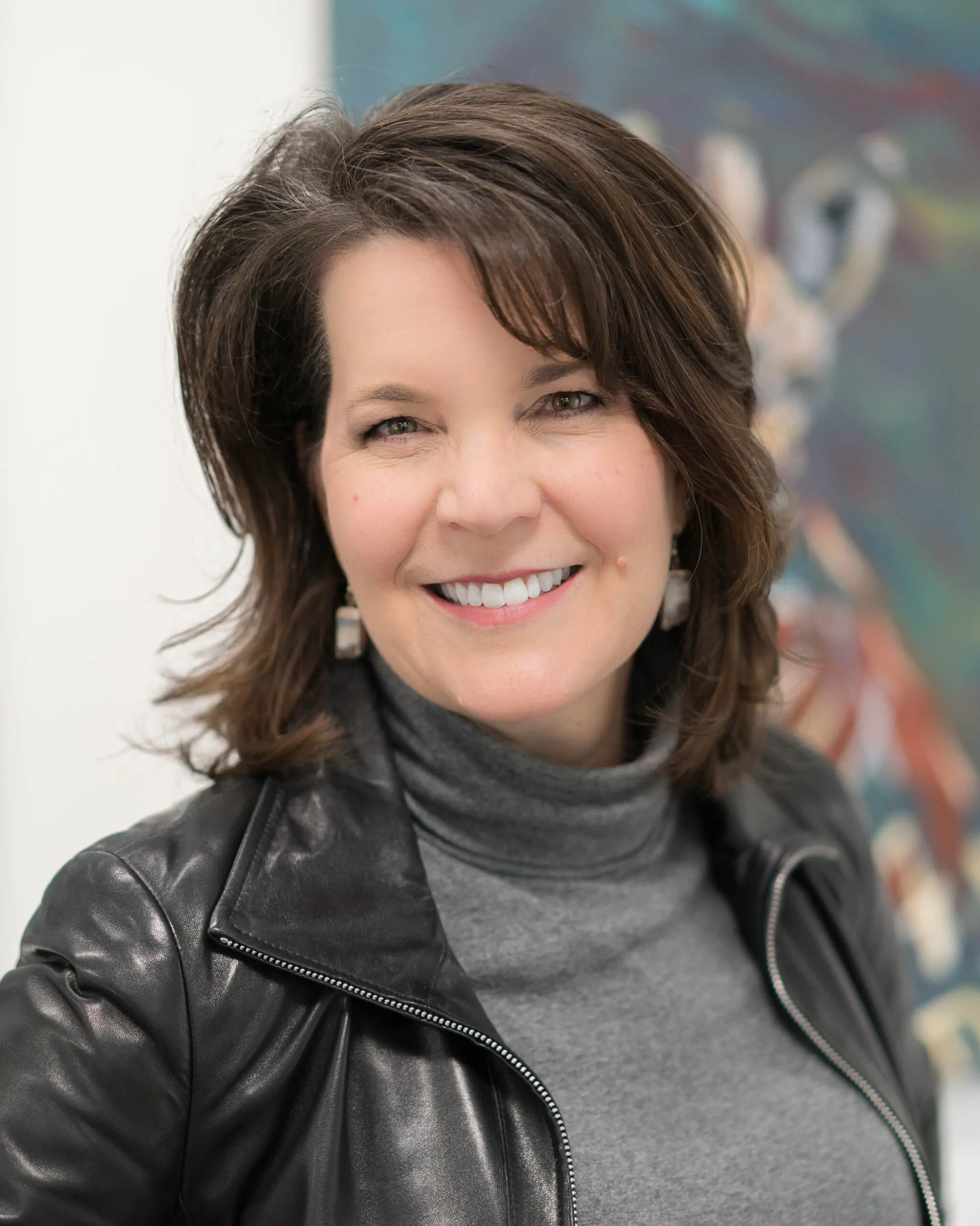 A Caucasian woman posing for a headshot in a black leather jacket